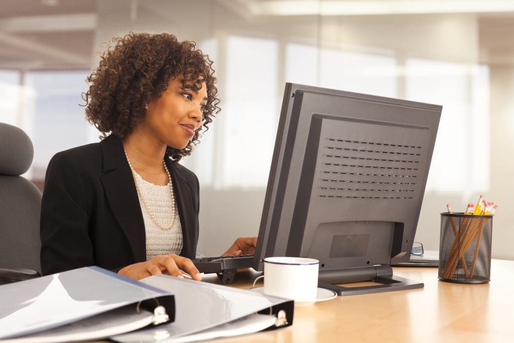 Young businesswoman using computer at desk indoors office building
